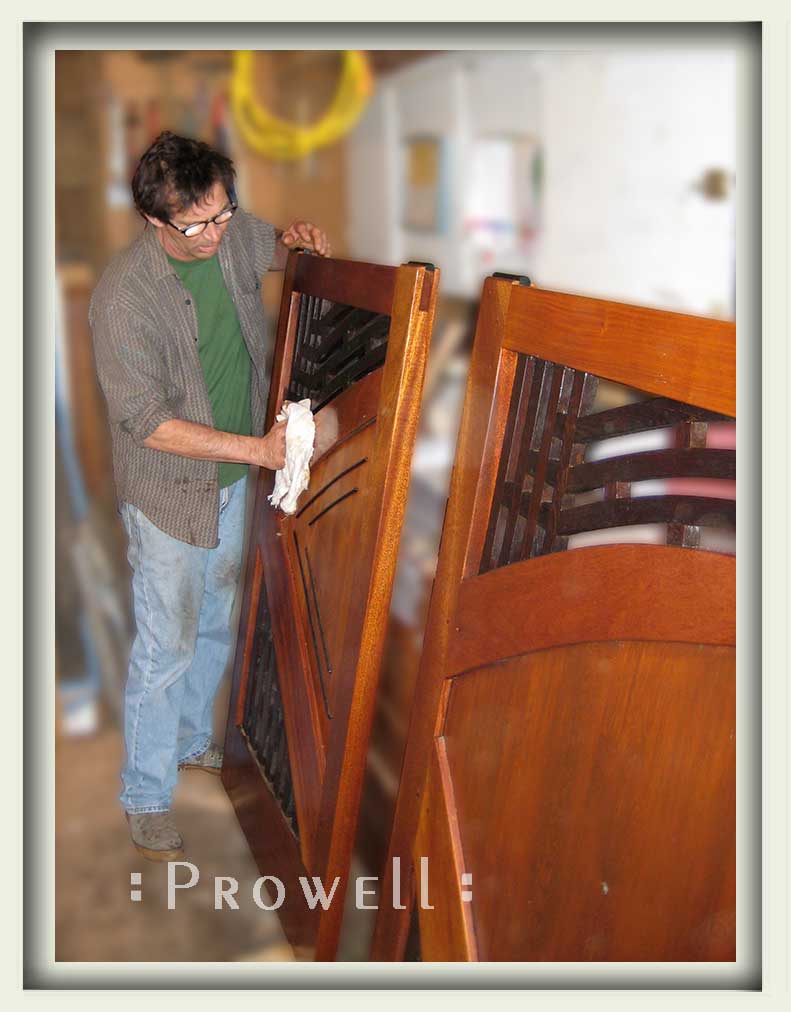 Photograph in the wood shop with charles applying the finish to modern wooden gate #202