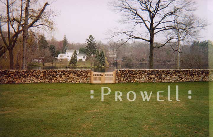 site photograph showing a low stone wall and the arched wood gates #96=2 in Connecticut
